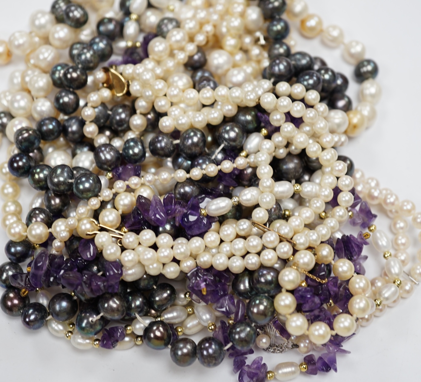 Four assorted modern cultured pearl necklaces, including Tahitian pearl, 133cm and a graduated single strand with 750 clasp, together with a two double strand cultured pearl bracelets, one with 14k clasp, an amethyst and